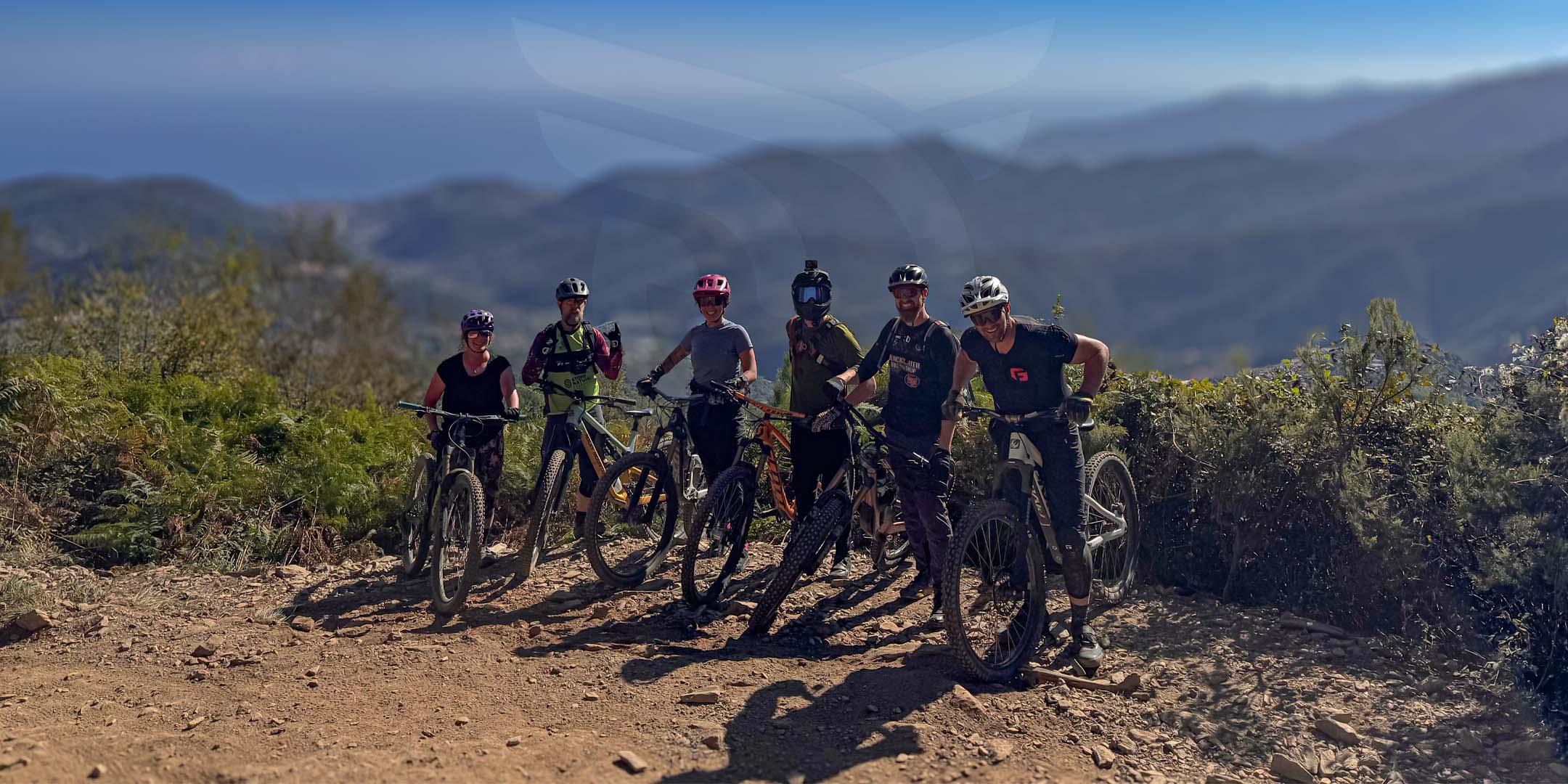 Group of mountain bikers on a trail with scenic mountains in the background. Italy - Flat TIre Adventures