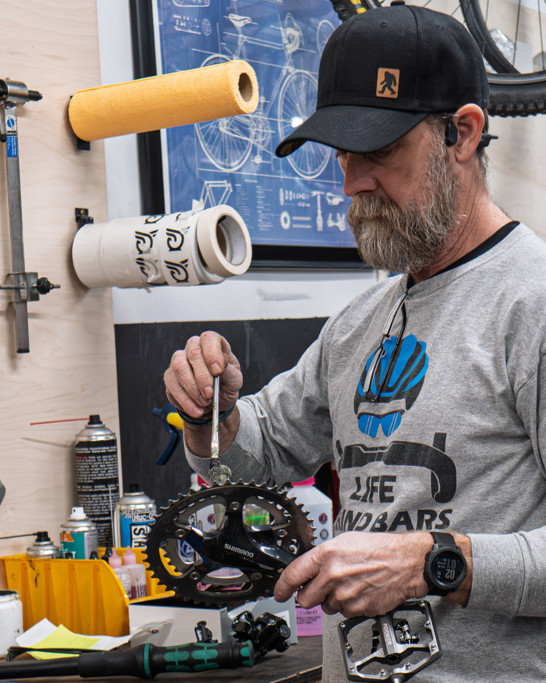 Jason working on a bicycle chain in a workshop with tools in Greensburg, PA